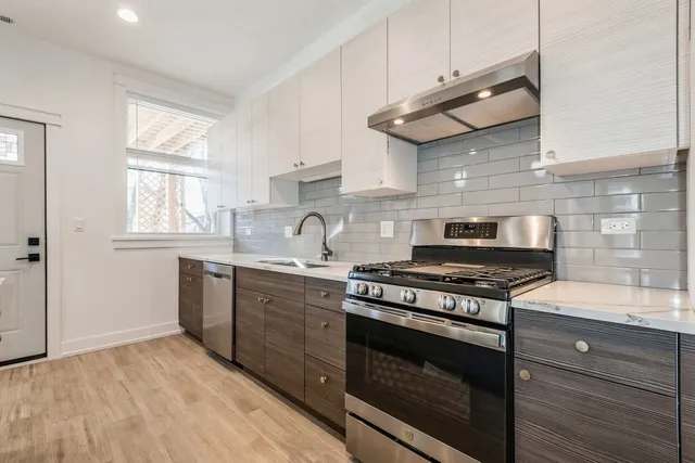 a kitchen with stainless steel appliances a stove a sink and cabinets