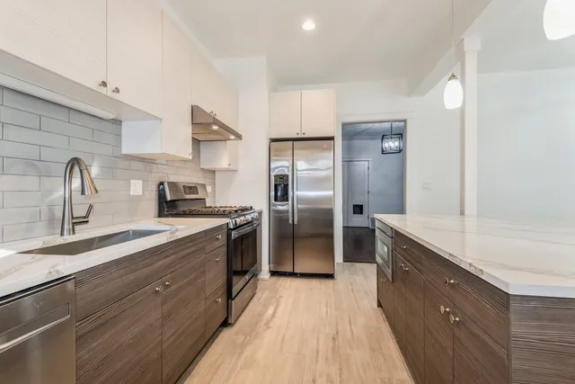 a kitchen with granite countertop a refrigerator and a sink
