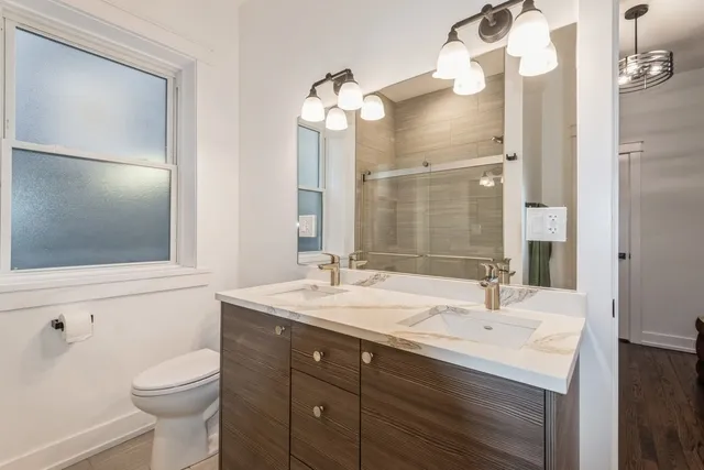 a bathroom with a sink a toilet and a mirror