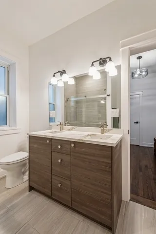 a bathroom with a granite countertop sink mirror and a toilet