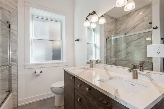 a bathroom with a sink a toilet and a mirror