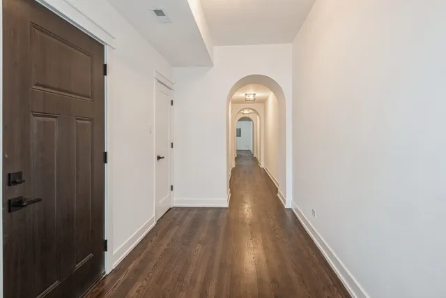a view of a hallway with wooden floor