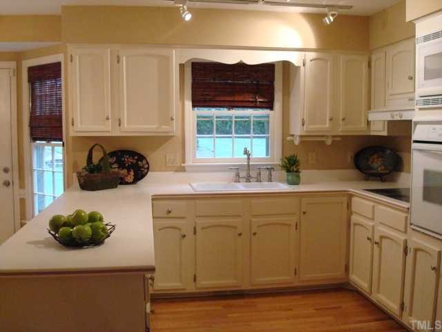 3700 St Marks Road Durham, NC 27707 - Photo 7 of 12 Kitchen has updated light fixtures, new hardwood floors, recent paint, bar which separates kitchen and large eat in area, desk with built in shelving above.