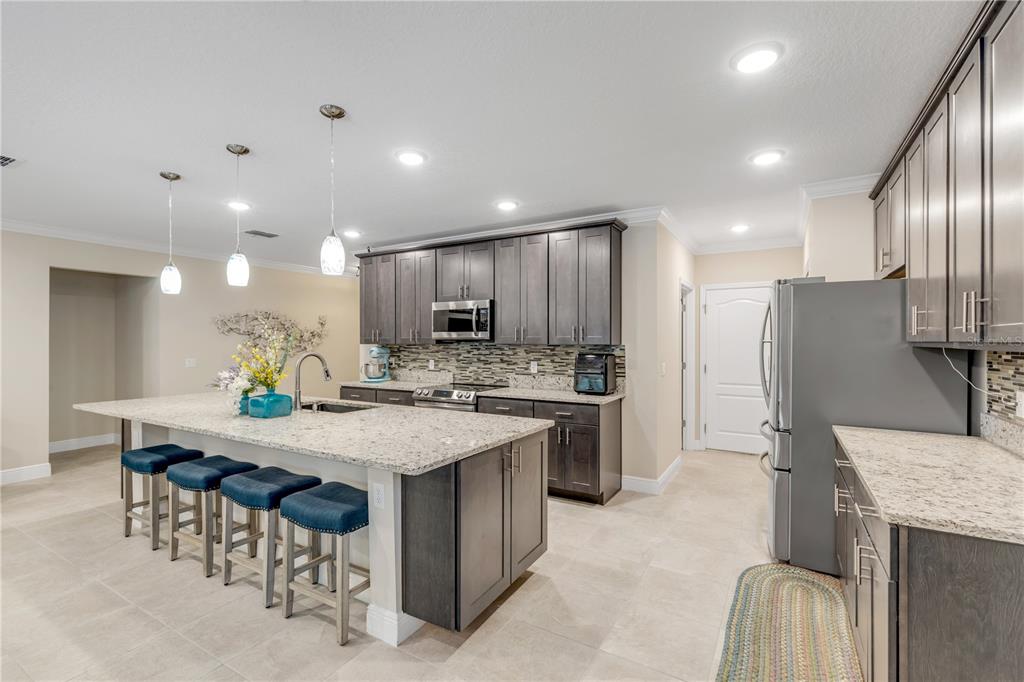 2504 Lime Tree Drive Edgewater, FL 32141 - Photo 11 of 42 a kitchen with stainless steel appliances granite countertop a kitchen island a stove a table and chairs