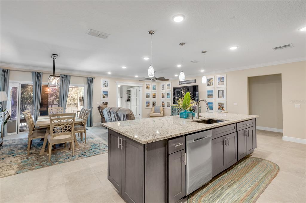 2504 Lime Tree Drive Edgewater, FL 32141 - Photo 13 of 42 a kitchen with kitchen island granite countertop a table and chairs