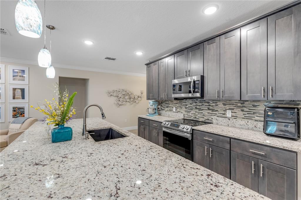 2504 Lime Tree Drive Edgewater, FL 32141 - Photo 14 of 42 a kitchen with stainless steel appliances granite countertop a sink stove and refrigerator