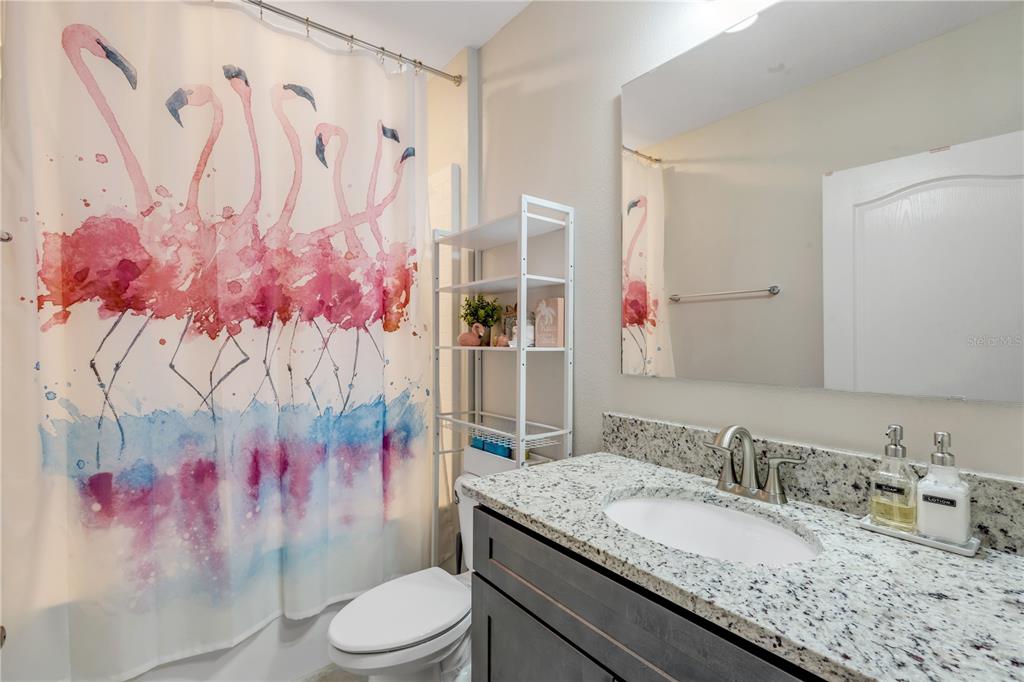 2504 Lime Tree Drive Edgewater, FL 32141 - Photo 24 of 42 a bathroom with a granite countertop sink mirror vanity and toilet