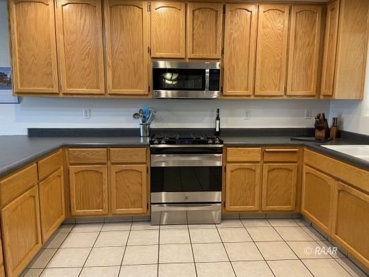 304 South Gateway Boulevard Ridgecrest, CA 93555 - Photo 9 of 30 a kitchen with granite countertop a stove top oven microwave and cabinets