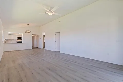 a view of a kitchen with wooden floor and a ceiling fan
