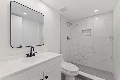 a bathroom with a sink a toilet and shower