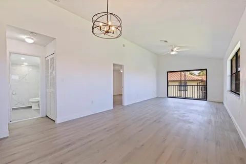 a view of empty room with wooden floor and window