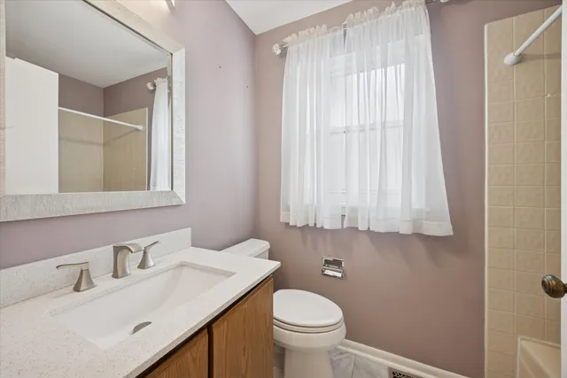 a bathroom with a sink vanity mirror and toilet