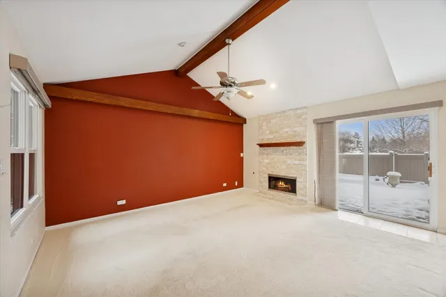 an empty room with fireplace and windows