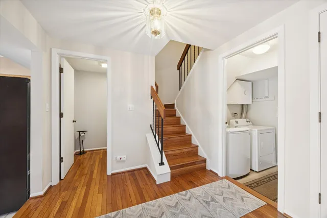 a view of a hallway with wooden floor and staircase