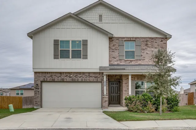 a front view of a house with a garden and garage