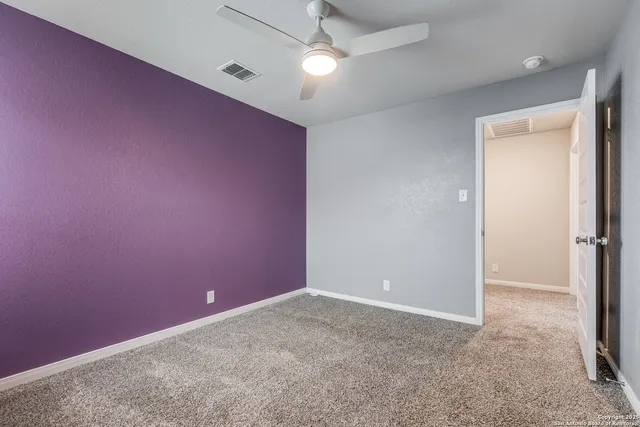 an empty room with a ceiling fan