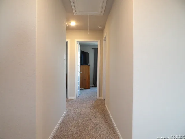 a view of a hallway with wooden shelves