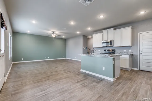 a kitchen with a refrigerator and white cabinets