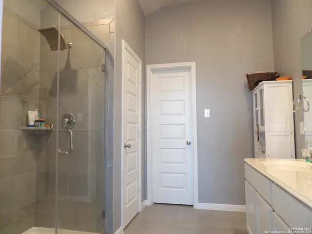 a bathroom with a granite countertop sink a shower and a mirror
