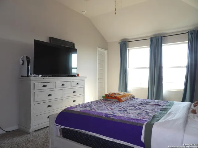 a bedroom with a large bed and a flat screen tv