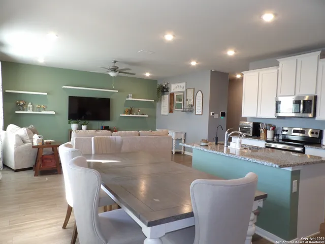 a living room with furniture a flat screen tv and kitchen view