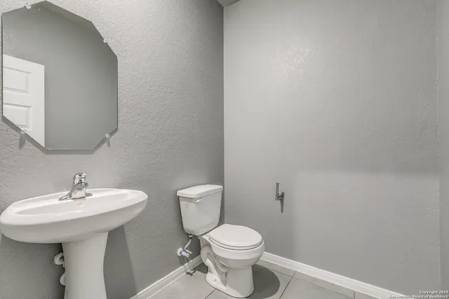 a bathroom with a sink toilet and a mirror