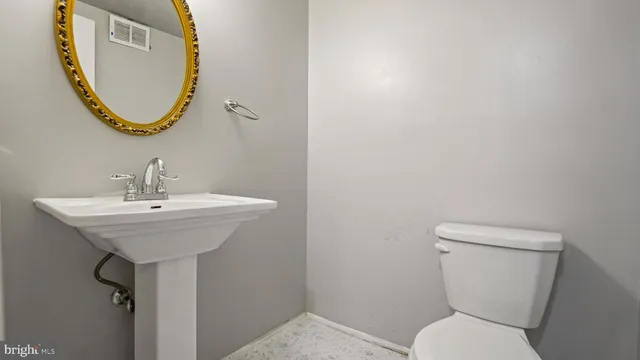 a bathroom with a toilet a sink and a mirror
