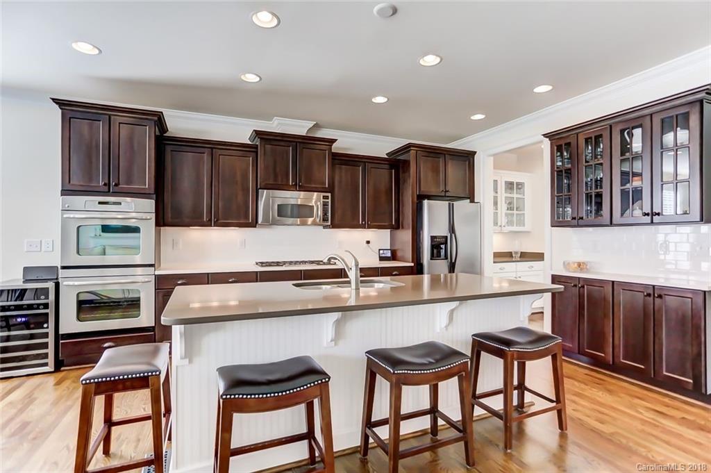 754 Revival Row Fort Mill, SC 29708 - Photo 14 of 35 a kitchen with stainless steel appliances granite countertop a stove top oven a refrigerator a sink and chairs