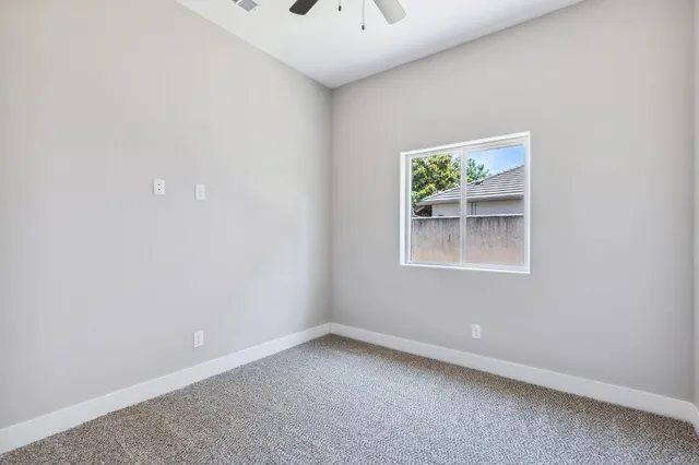 an empty room with a window and a potted plant