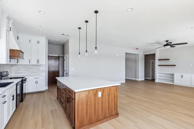 a kitchen that has a lot of cabinets and wooden floor