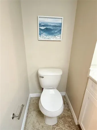 a bathroom with a toilet and a painting
