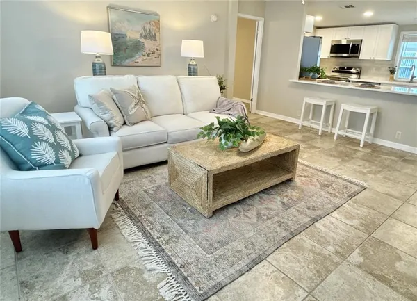 a living room with furniture and a dining area with kitchen view