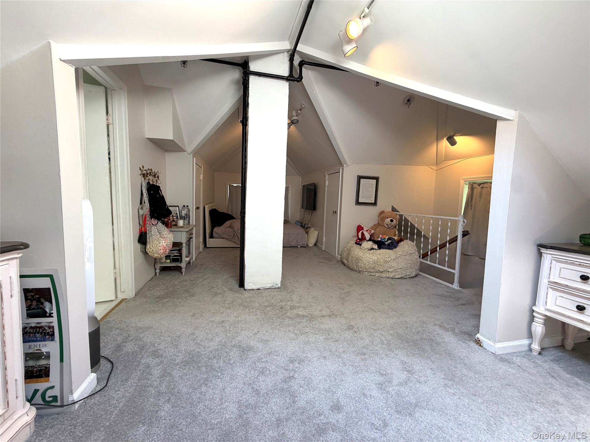 149 Fort Salonga Road Northport, NY 11768 - Photo 9 of 23 Carpeted loft area featuring sloped ceilings, track lighting, white painted trim, and a white baluster railing