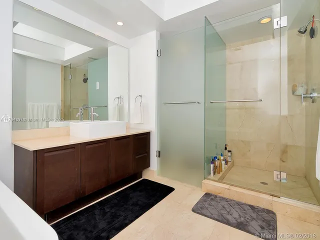 a bathroom with a double vanity sink a mirror and a bathtub