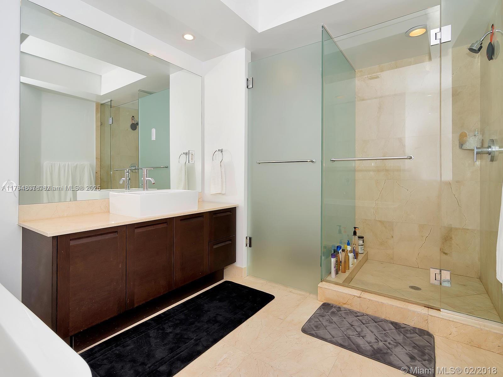 250 Sunny Isles Boulevard, Unit 31403 Sunny Isles Beach, FL 33160 - Photo 11 of 24 a bathroom with a double vanity sink a mirror and a bathtub