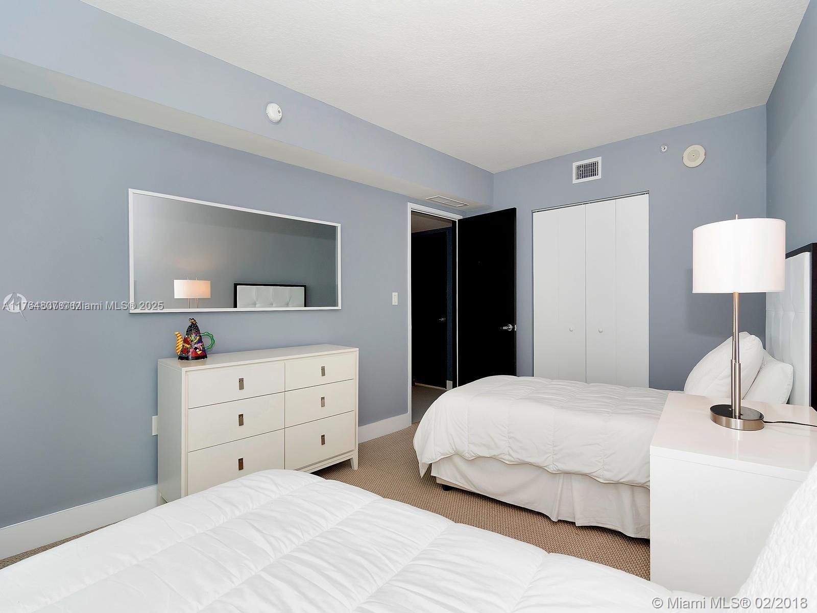 250 Sunny Isles Boulevard, Unit 31403 Sunny Isles Beach, FL 33160 - Photo 16 of 24 a bedroom with a bed and a dresser