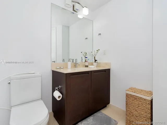 a bathroom with a sink a toilet and mirror