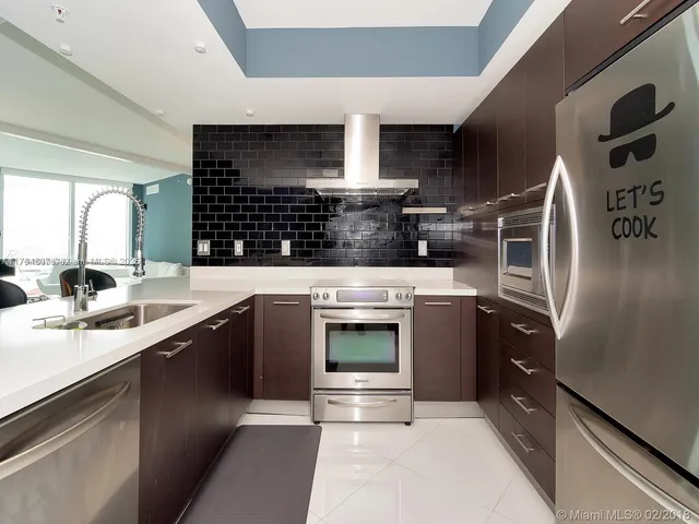 a kitchen with stainless steel appliances kitchen island a sink stove and cabinets