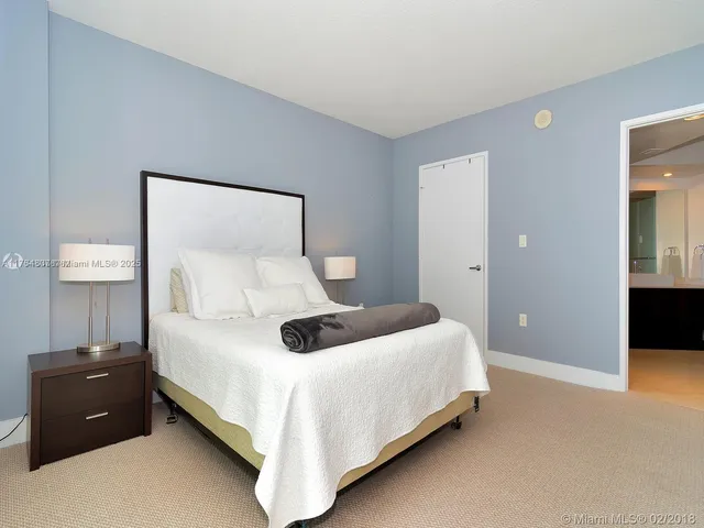 a bedroom with a bed and a lamp