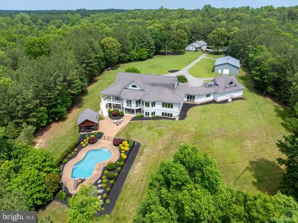 an aerial view of a house with a swimming pool outdoor seating and yard