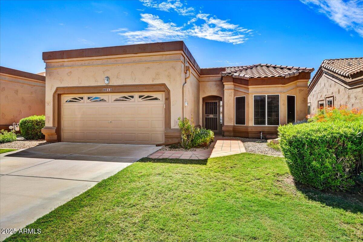 9013 West Marco Polo Road Peoria, AZ 85382 - Photo 3 of 30 a front view of a house with a yard and garage