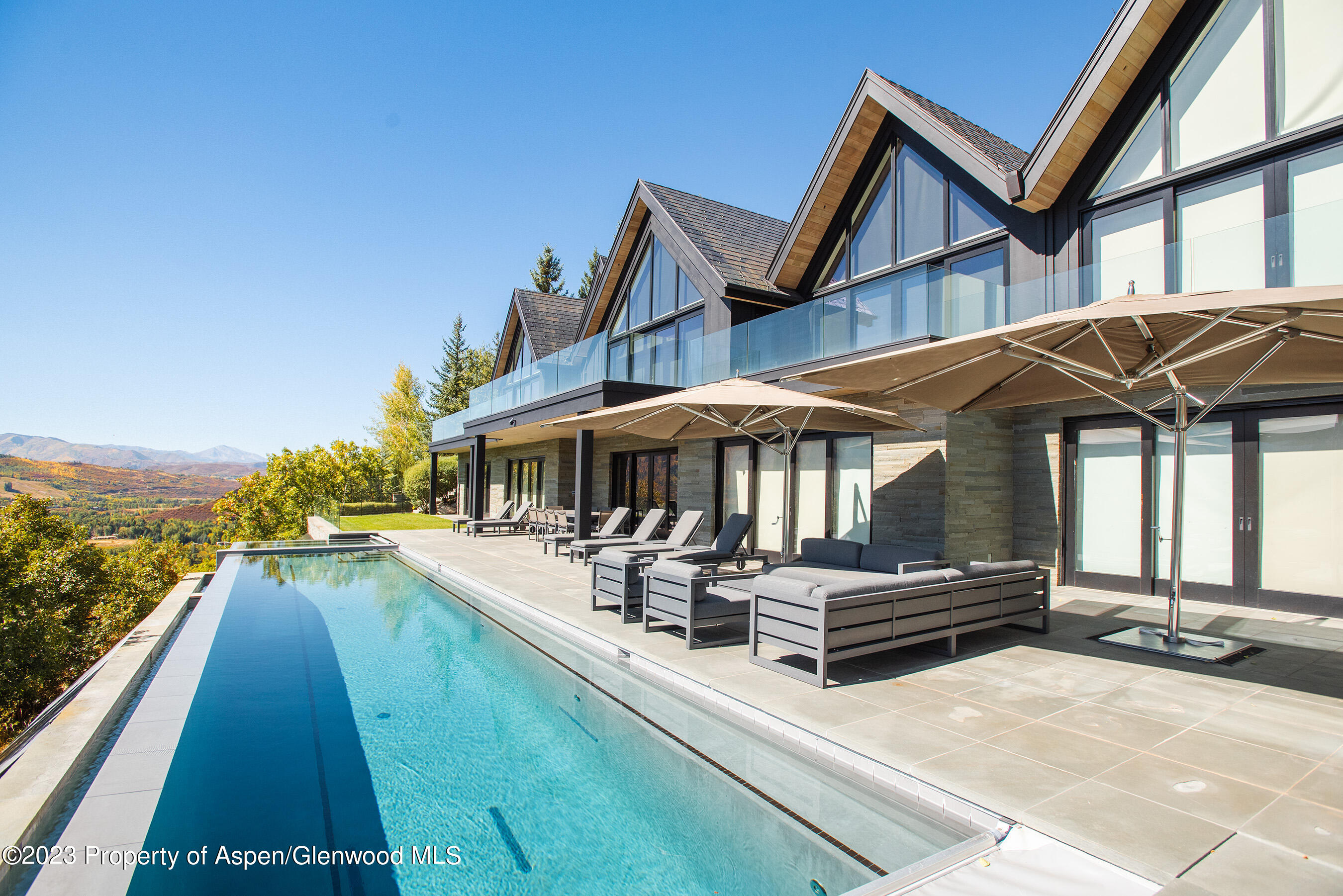 257 Ridge Road Aspen, CO 81612 - Photo 1 of 47 a patio with a table and chairs under an umbrella