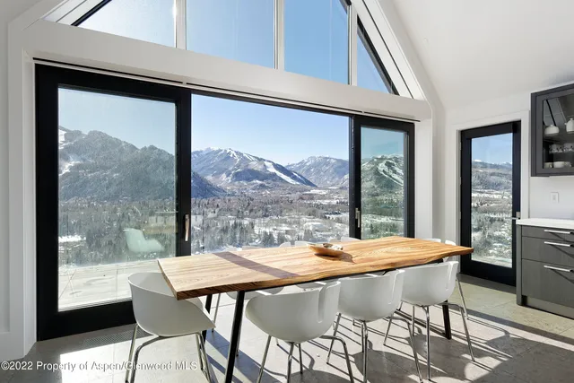 a view of a dining room with furniture large window and outside view