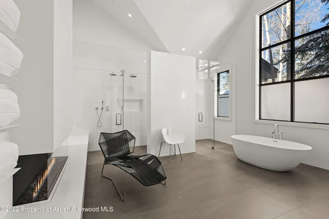 a spacious bathroom with a double vanity sink a mirror and a bathtub