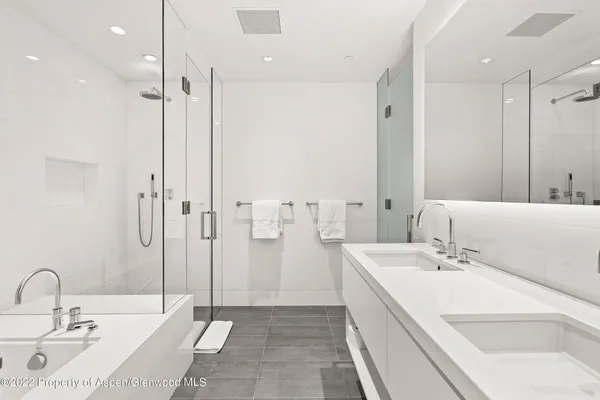 a bathroom with a double vanity sink mirror and shower