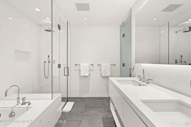 a bathroom with a double vanity sink mirror and shower