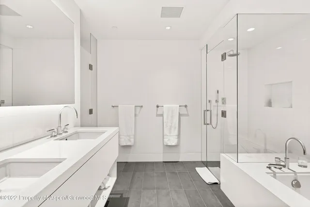a bathroom with double vanity sink and a mirror