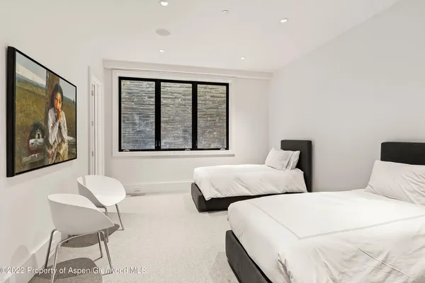 a bedroom with two beds and a large window