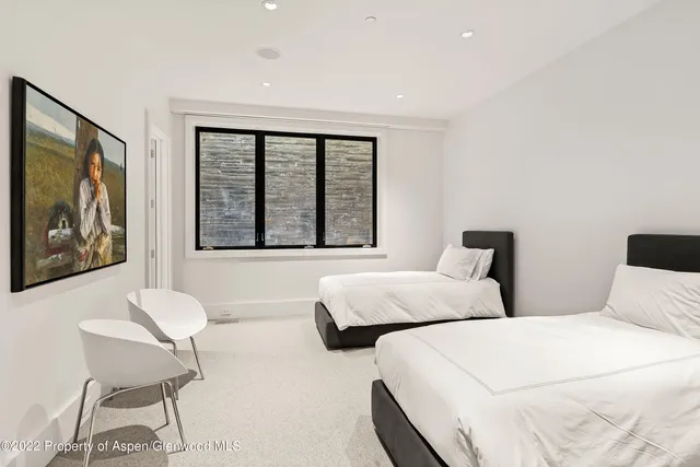 a bedroom with two beds and a large window