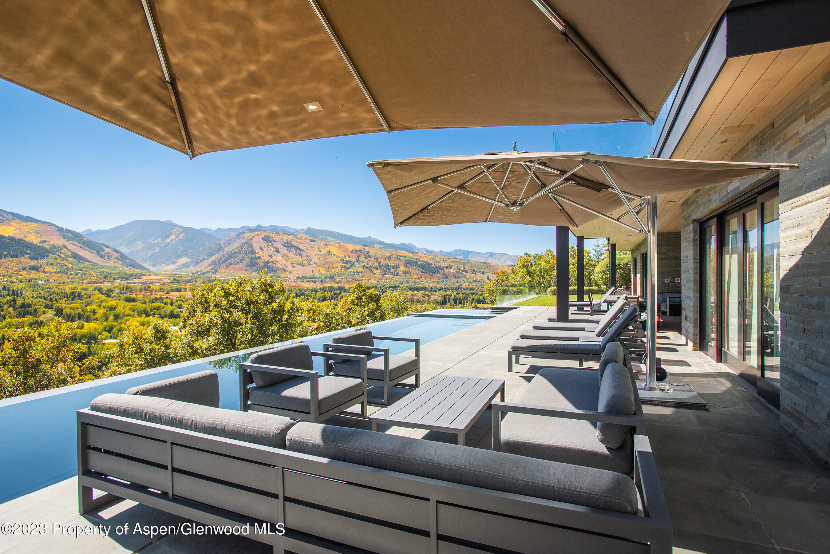 257 Ridge Road Aspen, CO 81612 - Photo 38 of 47 a roof deck with a table and chairs under an umbrella